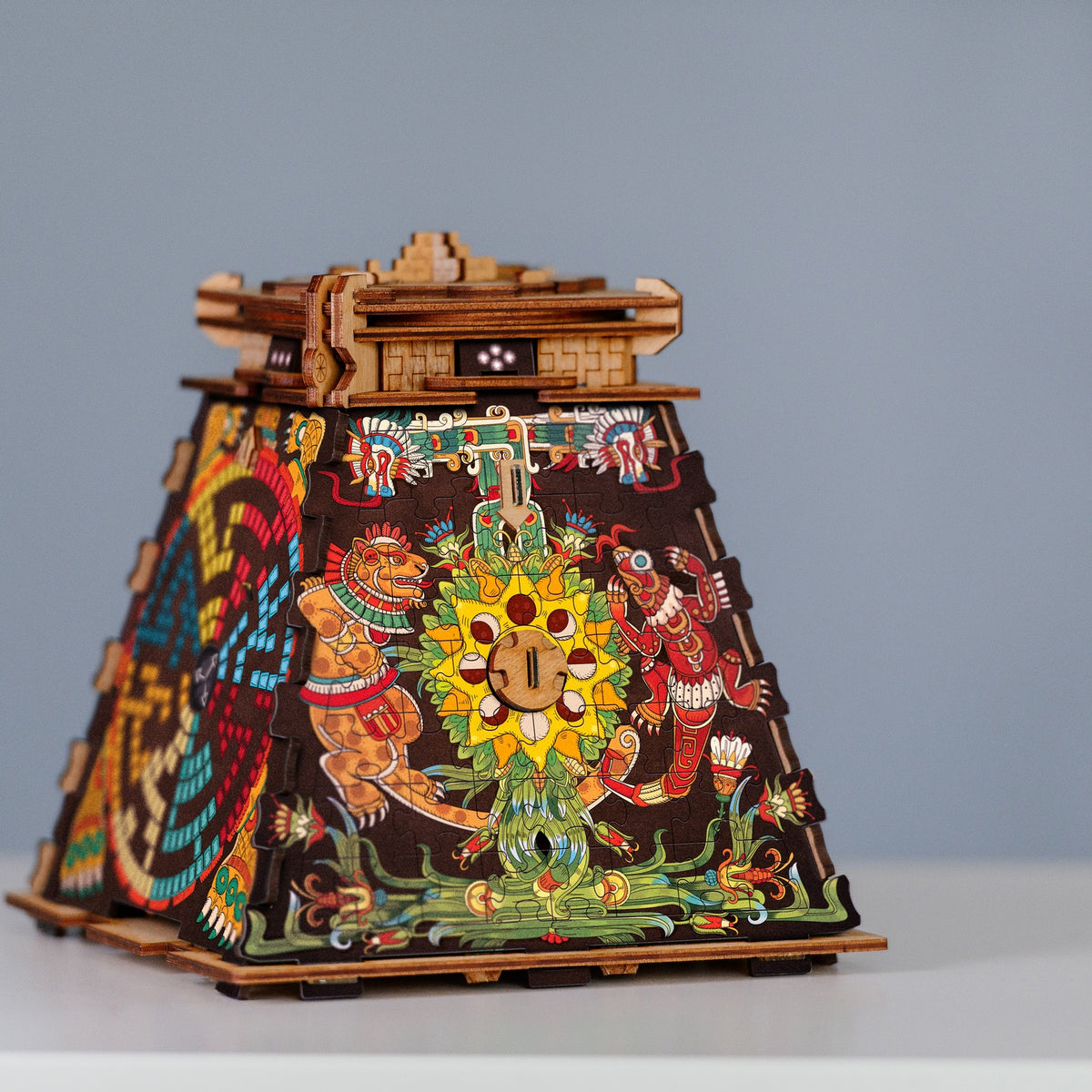 Top af Cluebox: Pyramid of the Sun i træpuzzle-format med farverige aztekiske illustrationer og synligt nøglehul