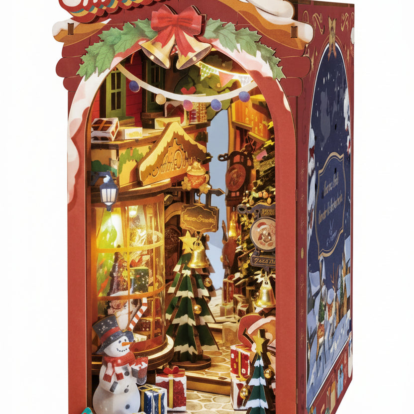 Miniature julegate med rød bue ’Merry Christmas’, oplyste huse, juletræ, snemand og gaver