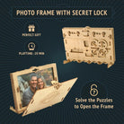 Træfarvet puzzlebox formet som billedramme med hemmelig lås, vist åben med foto og løst frontpanel.