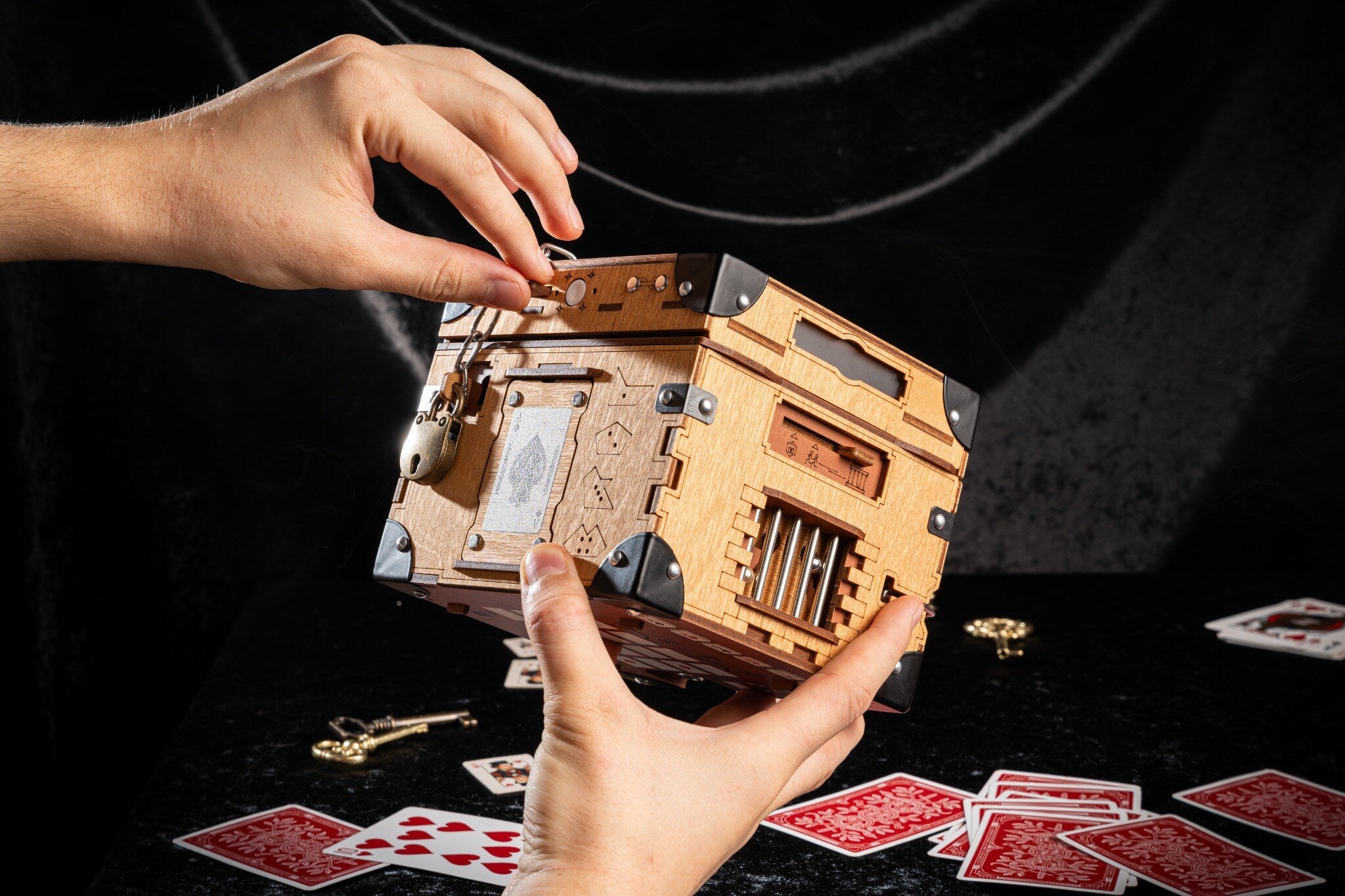 Houdini Double Escape Bundle træ-escape box holdt i hænder, toplåg med hængelås og udsmykkede metalhjørner synligt